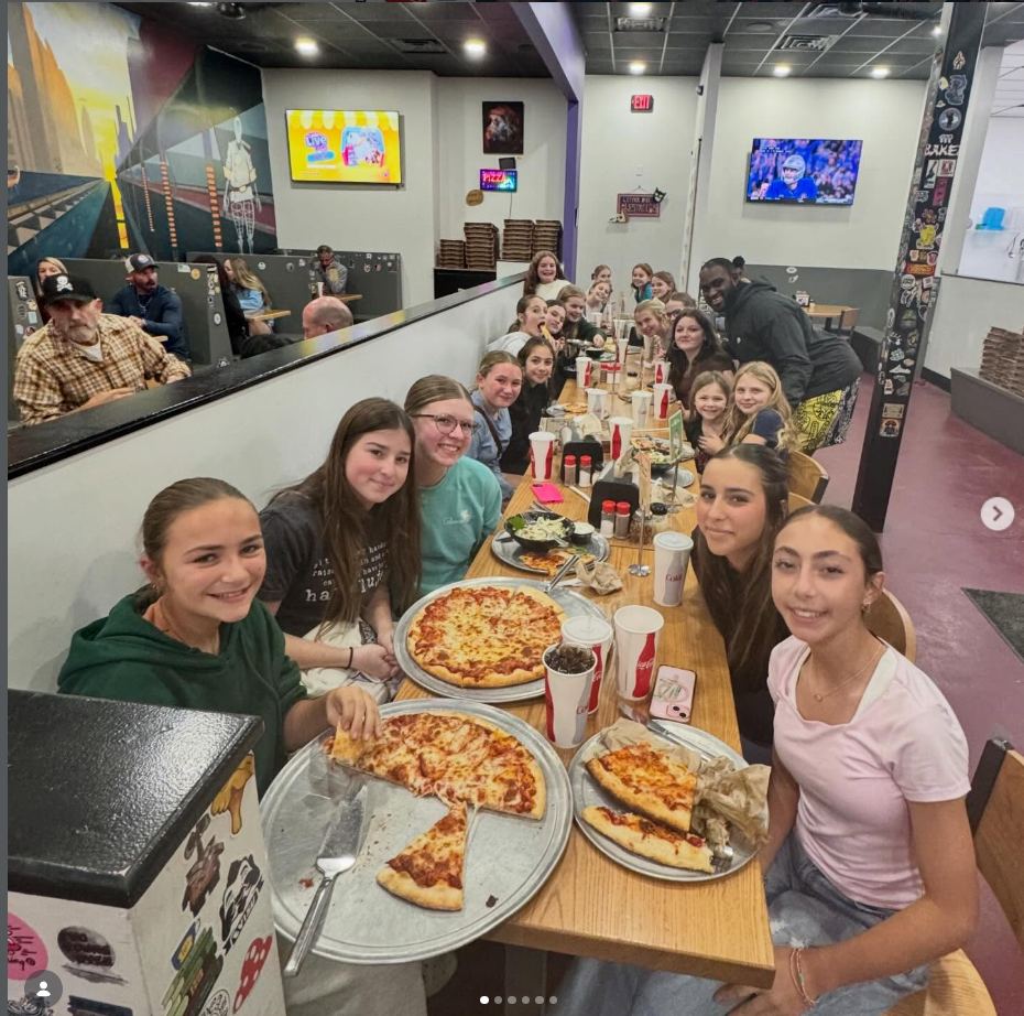 Nassau Heat players eating pizza together after a tournament